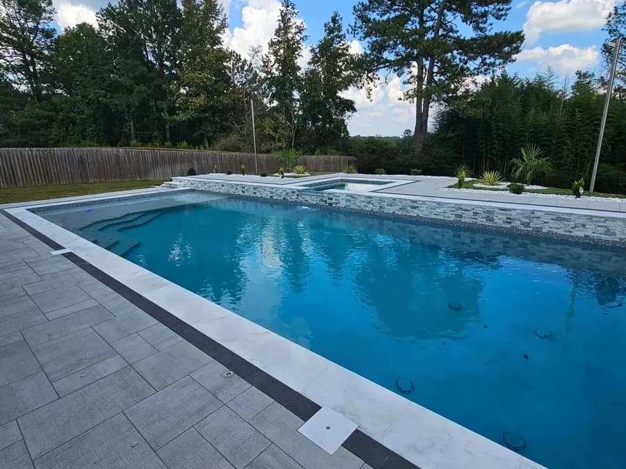 Modern rectangular gunite pool with paver decking by Anthem Pools