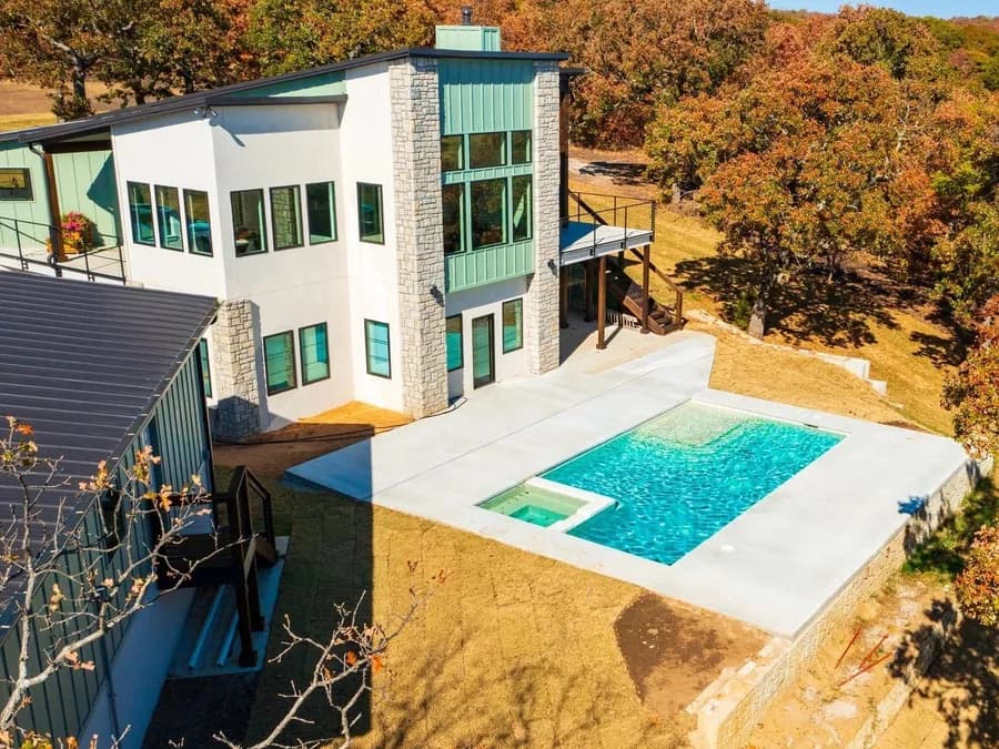 Hillside pool and spa set into a graded, walled backyard by Anthem Pools